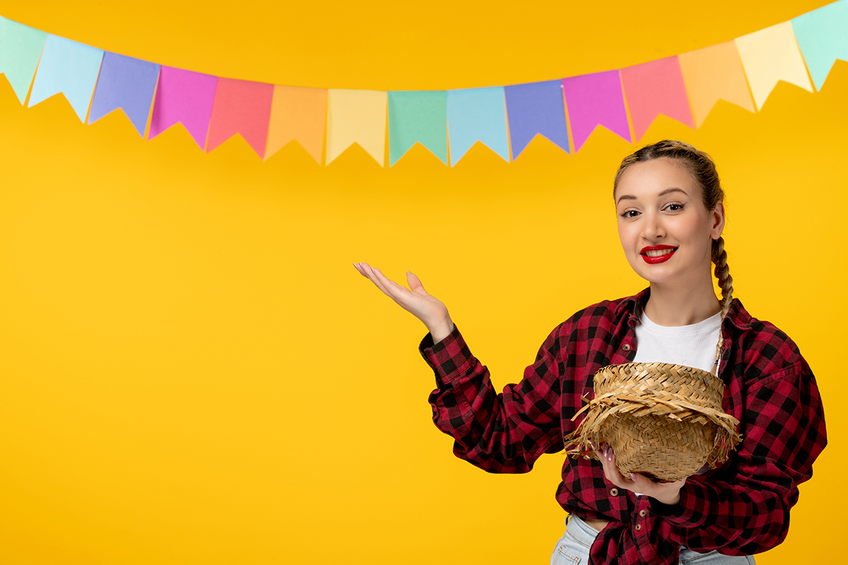festa junina blonde cute girl holding straw hat off brazilian festival with colorful flags